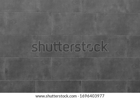 The texture of the black tile wall. Background of black tiled wall. Rectangular tile.
