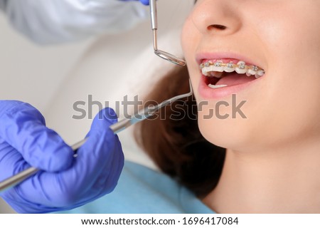Teenage girl with dental braces visiting orthodontist in clinic Royalty-Free Stock Photo #1696417084