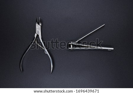 Silver nail clippers on a black background