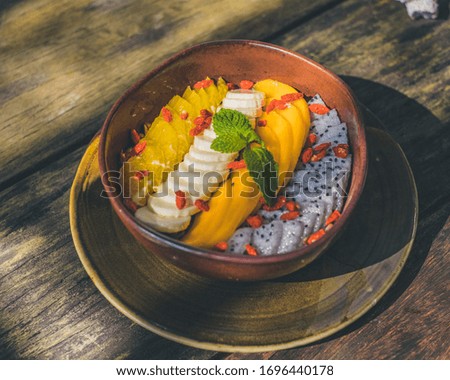 smoothie bowl with mango banana dragon fruit in beautiful wooden plate