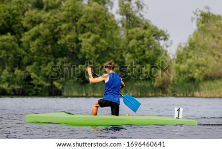 canoe single men paddles on lake in canoeing sprint