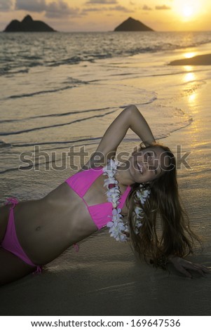 girl in bikini at the beach at sunrise in hawaii