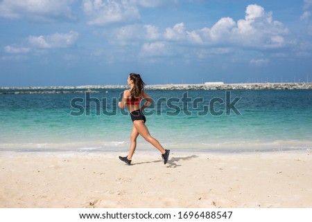Athletic Woman Running on the Beach. Female Runner Jogging. Outdoor Workout.