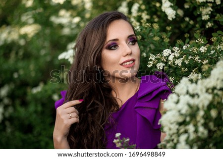 portrait of a beautiful young girl in a purple dress in bloom of white flowers, photo shoot of a girl, beautiful lilac