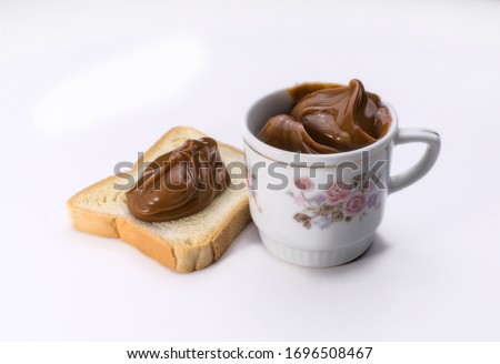 Traditional Argentine milk candy on toast and in a porcelain bowl. (White background)