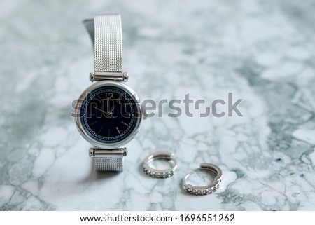 Top view of stylish woman watch. Elegant swiss wristwatches lying on grey background.Time passing.