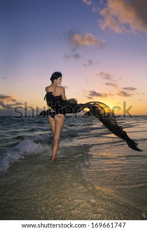 beautiful woman in bikini at the beach at sunrise