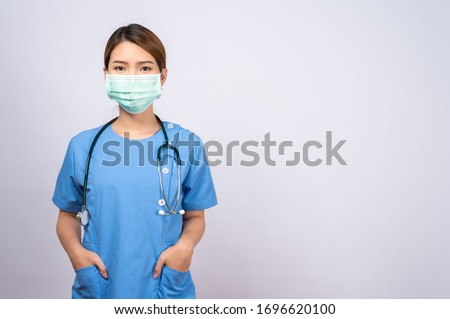 Portrait of young asian nurse wearing surgical mask Royalty-Free Stock Photo #1696620100