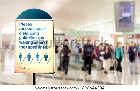 a sign inside an airport warns of the need to maintain the minimum safety distance between people to avoid contagion during the COVID-19 Coronavirus pandemic. Airport security measures. Royalty-Free Stock Photo #1696644304