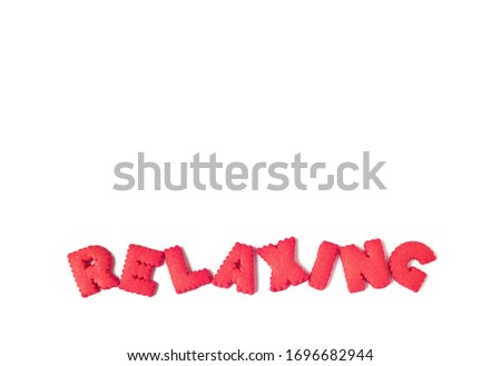 Text RELAXING spelled with red alphabet shaped cookies on white background