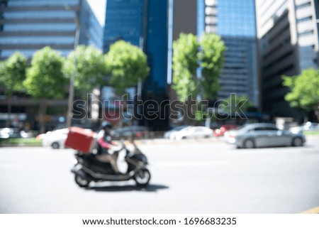 Abstract blurred background of cars driving on the road, traffic in the city with business building  background