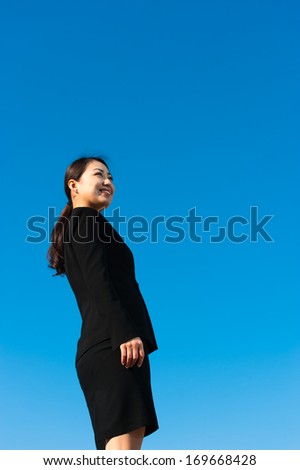 Women who look up at the sky wearing a suit