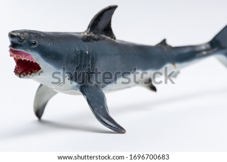 Plastic toy great white shark on a seamless white background closeup with detail.