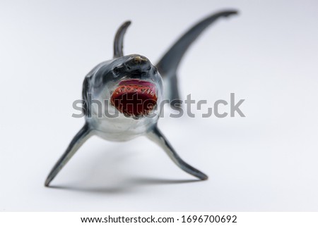 Plastic toy great white shark on a seamless white background closeup with detail.