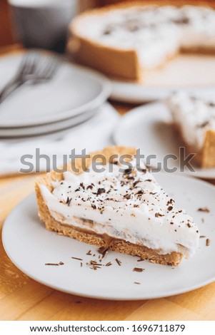 appetizing slice of sand-based dessert with white cream cheese and banana stuffing sprinkled with grated chocolate