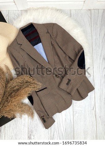 Brown tweed jacket with stripes on the elbows on a wooden background