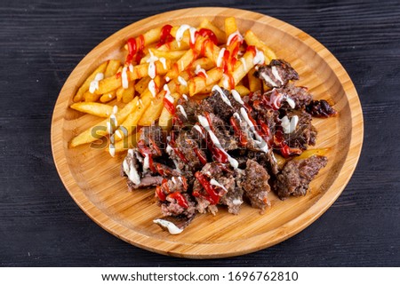 Fried beef meat, served with fries and ketchup with mayonnaise
