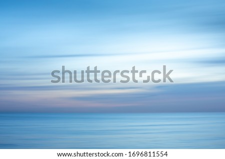 Intentional camera movement creating a dreamy, blurred effect of the sea at Brighton and Hove, East Sussex. Royalty-Free Stock Photo #1696811554