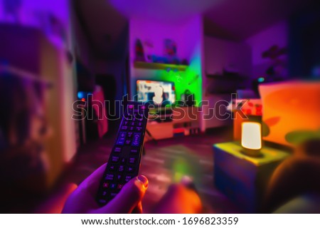 Man watching tv in a colorful living room at night