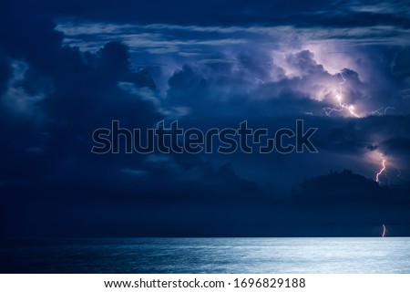 Massive cumulus clouds and lightning at night over the Black sea Royalty-Free Stock Photo #1696829188