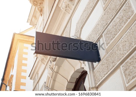 Empty, clean small rectangular sign for company logo mockup on modern city center building wall