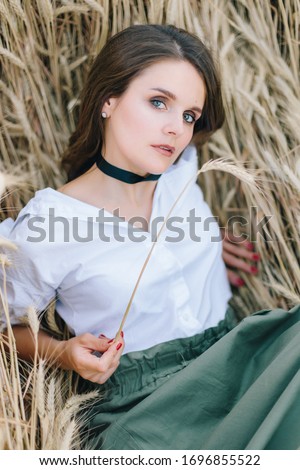 beautiful photo session of a stylish girl in a wheat field at sunset in summer