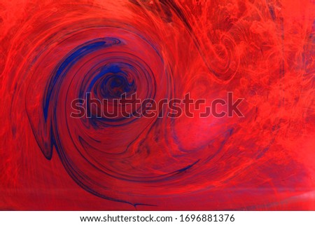streaks of red and blue paint dissolve in water. Smoke, a witch's potion, the texture of flares. Abstract background, texture.