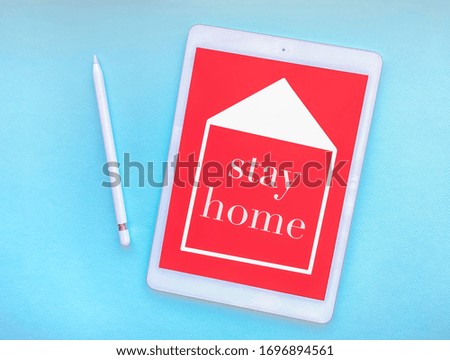 The words stay home on the tablet screen, the concept of quarantine at home as a preventive measure against the spread of coronovirus disease.