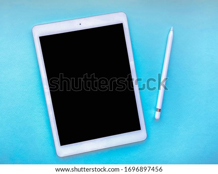 Tablet mock up on table with stylus isolated on blue background. Business concept.