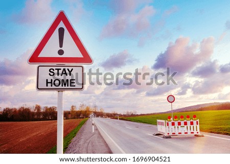  road sign with exclamation point and the words Stay Home