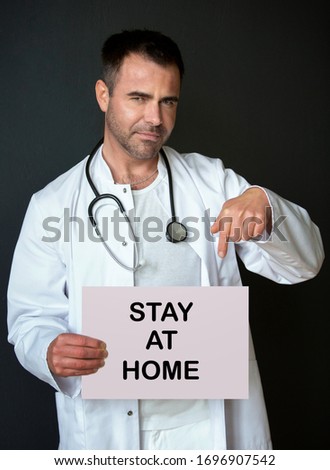 doctor holding a sign with the words Stay At Home