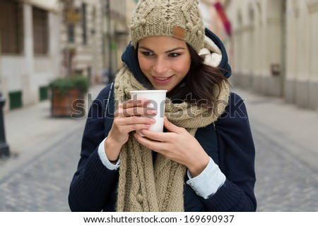 fashionable woman holding coffee outdoors