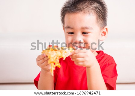 Hot Homemade, Vegetarian fast Italian food, Cute Little Child enjoying eating Delivery Pizza pepperoni, cheese many slices deliciously in an open cardboard box at home