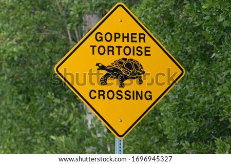 Caution indicated by Gopher Tortoise Crossing road sign in Florida at Ding Darling National Wildlife Refuge on Sanibel Island Royalty-Free Stock Photo #1696945327