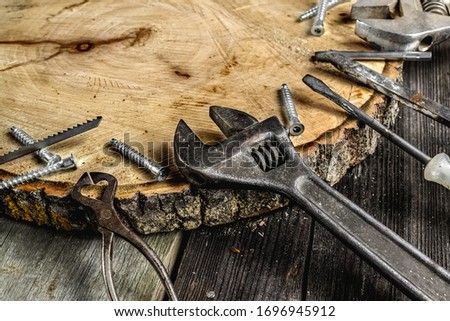 A set of metal tools in the workshop on an old rustic wooden background.concept.Father's day or labor day holiday.A greeting card or banner for your store or website.worker's day.Copyspace.Mock up