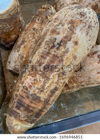 Taro root on a market display. A starchy tuberous root that soaks up flavor when cooked.
