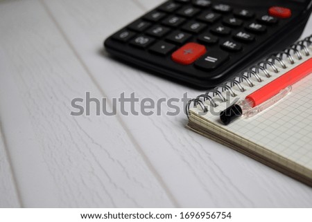 Calculator and a book isolated on office desk. Finance or business concept