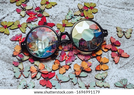 glasses with kaleidoscope lenses on a background of wooden butterflies