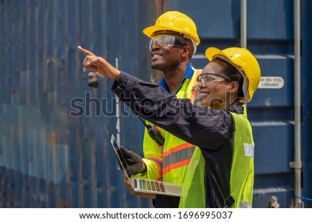 industrail background of african american containers yard and cargo inspector team working at containers loading area Royalty-Free Stock Photo #1696995037