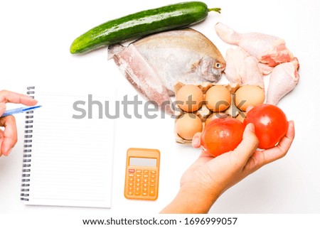 A flatlay picture of groceries and necessity food such as fish, chicken, tomatoes, cucumber and eggs on copyspace white background. Panic buying happen around the world caused by covid-19 lockdown.