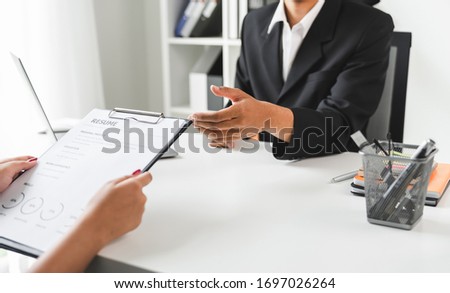 Young woman submit resume for a job interview in office. Quality employment concepts.