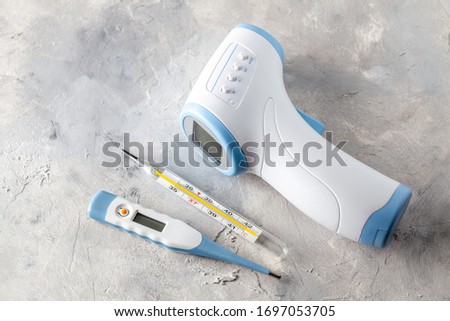 Electronic thermometer for measuring body temperature. Set of electronic thermometer, rectal, oral and glass mercury on gray background. Royalty-Free Stock Photo #1697053705