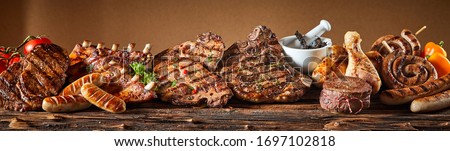 A selection of grilled gourmet meats on a rustic timber board. Royalty-Free Stock Photo #1697102818