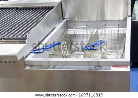 New empty modern professional deep fryer basket for  kitchen restaurant ; Food Industy background