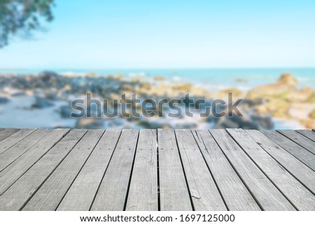 Empty Wood table top on blur sea or beach background.