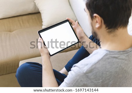 Male looking on tablet and entertaining himself