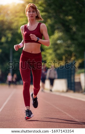Picture of young attractive fitness woman running outside.