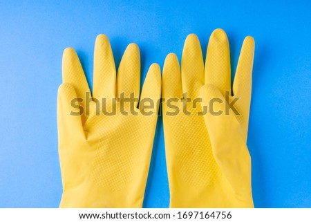 yellow gloves on a blue background, top view, selective focus.