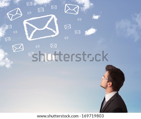 Businessman looking at mail symbol clouds on blue sky