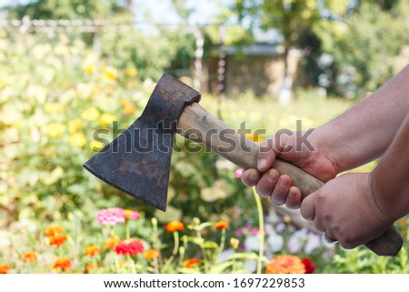the axe in his hands. men's hands hold an axe. the tool of the lumberjack